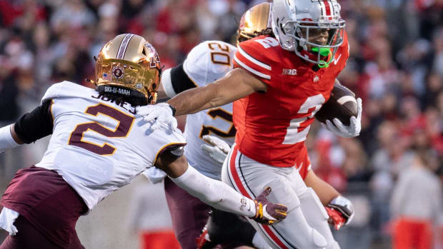 Nov 18, 2023; Columbus, Ohio, USA; Ohio State Buckeyes wide receiver Emeka Egbuka (2) runs past Minnesota Golden Gophers defensive back Tre'Von Jones (2) tackle attempt during the first half of their game on Saturday, Nov. 18, 2023 at Ohio Stadium.